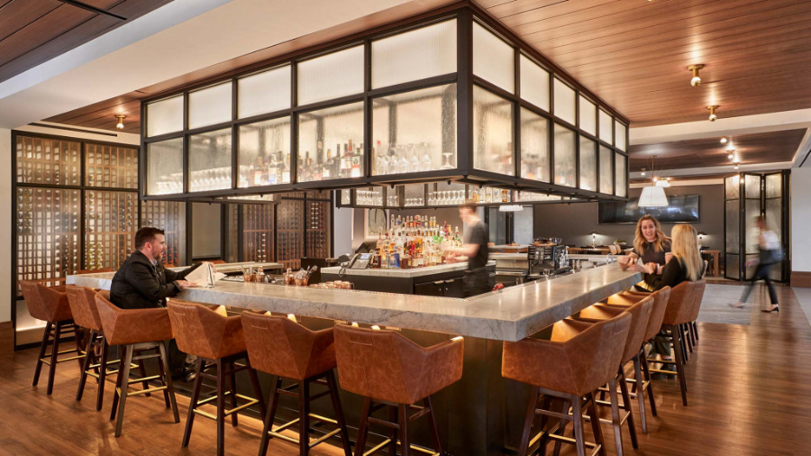 Gensler: Restaurant Interior Design Inspiration. The bar area, with many brown bar stools around the bar counter.